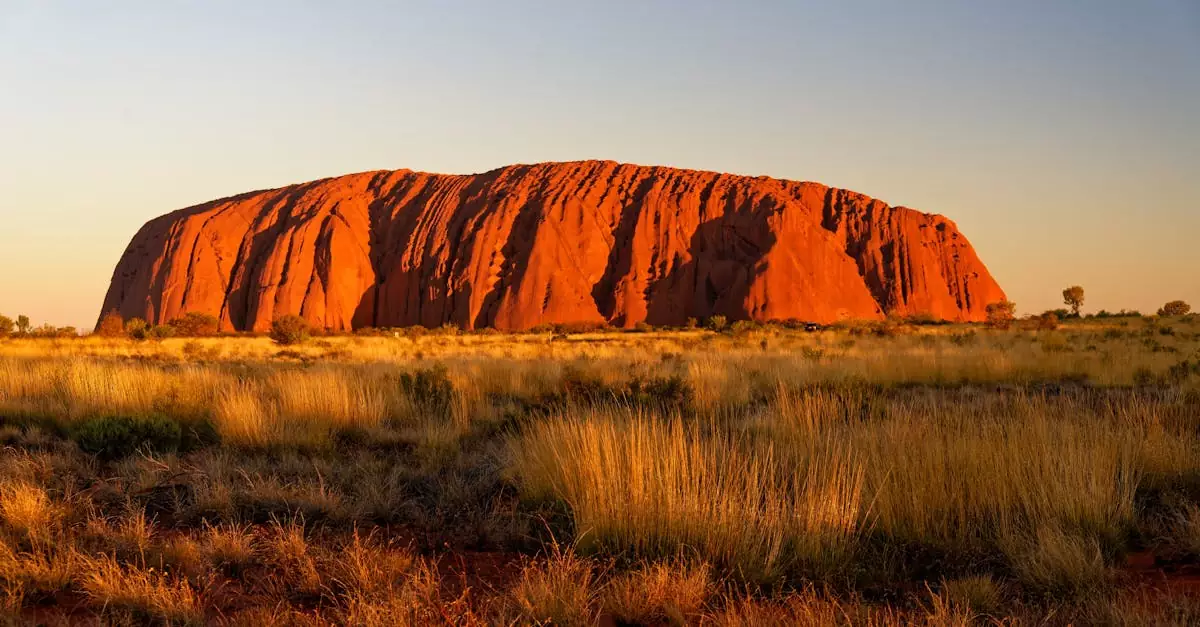 Stunning view of Uluru, Australia's iconic rock formation, at sunrise in the Outback.
