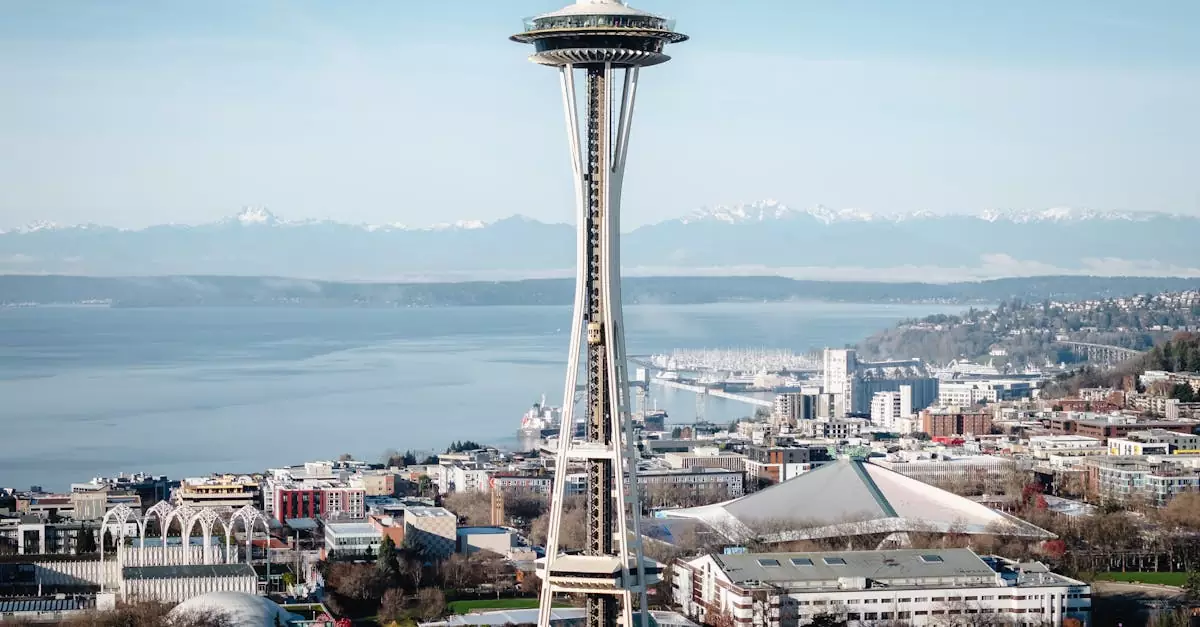 Aerial view of the Space Needle with Seattle's cityscape and mountains in the background.