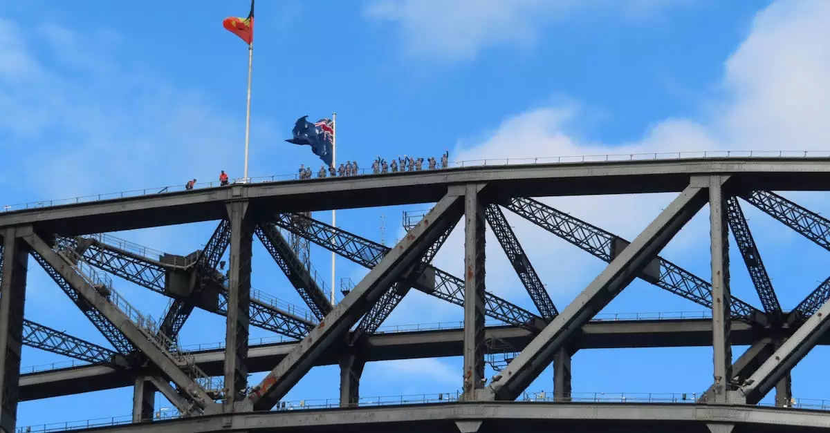 Sydney Harbour Bridge showcasing climbers and Australian flag against blue sky.