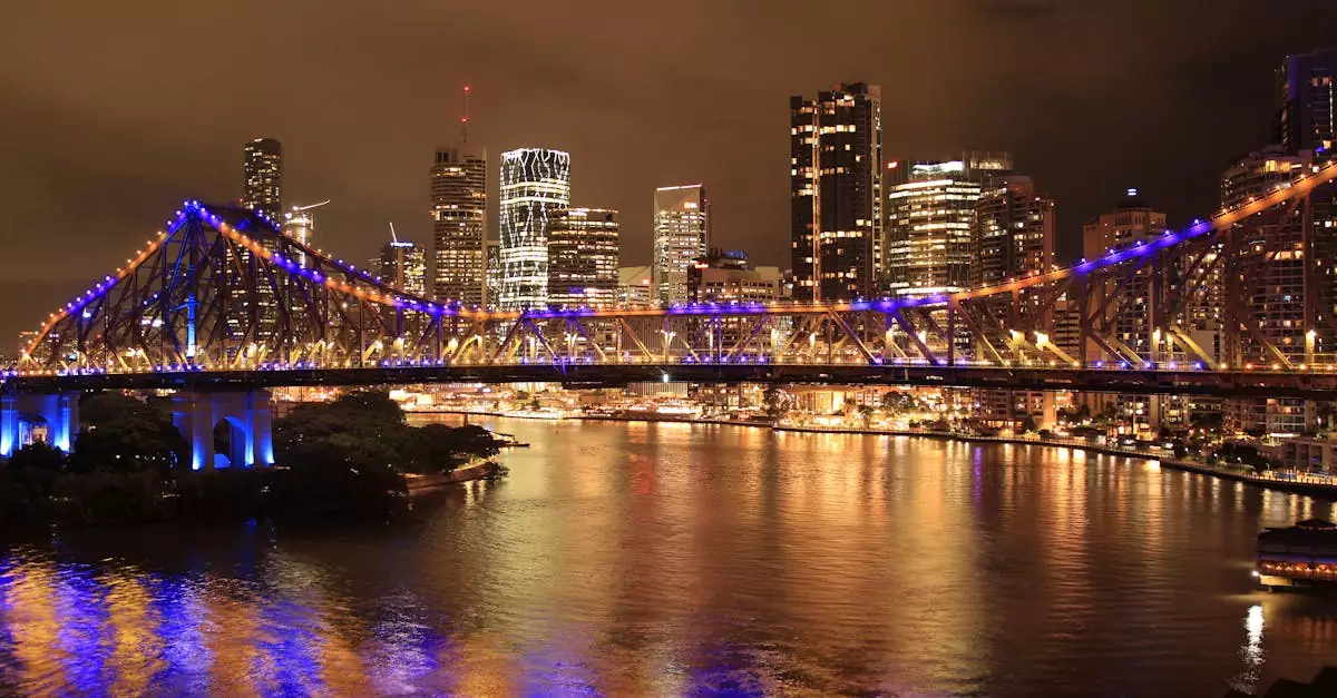 Stunning night view of Brisbane's Story Bridge illuminated in vibrant colors reflected on the river.
