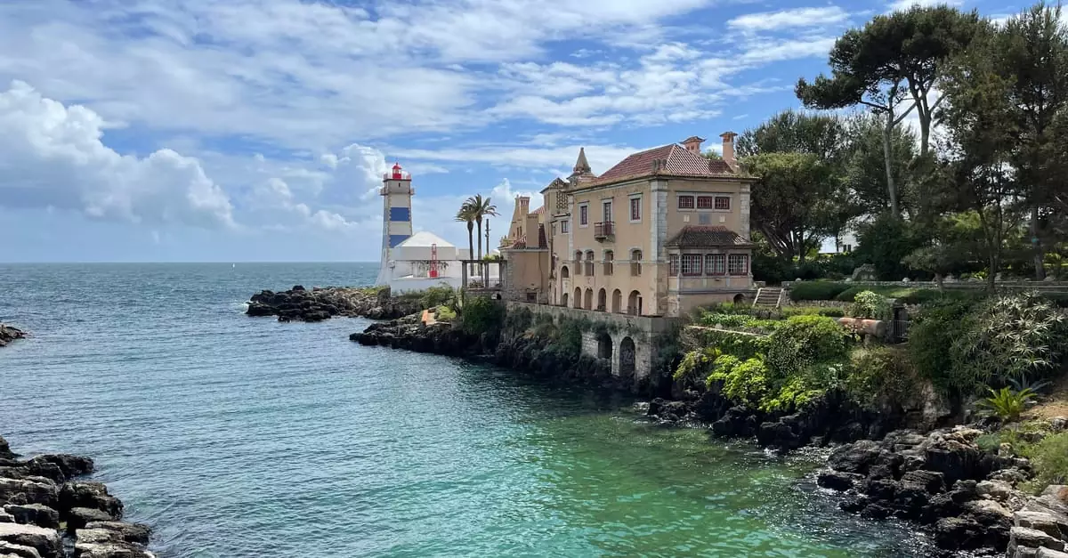 Picturesque view of a coastal lighthouse and historic building by the serene sea.