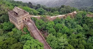 Drone shot of the Great Wall of China amidst lush greenery in Huairou, Beijing.