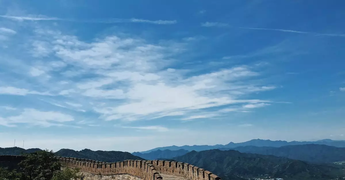 A breathtaking view of the Great Wall of China stretching across lush mountains under a vibrant blue sky.