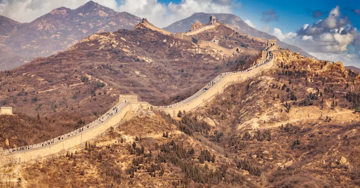 Scenic view of the Great Wall weaving through the mountainous terrain under a blue sky.