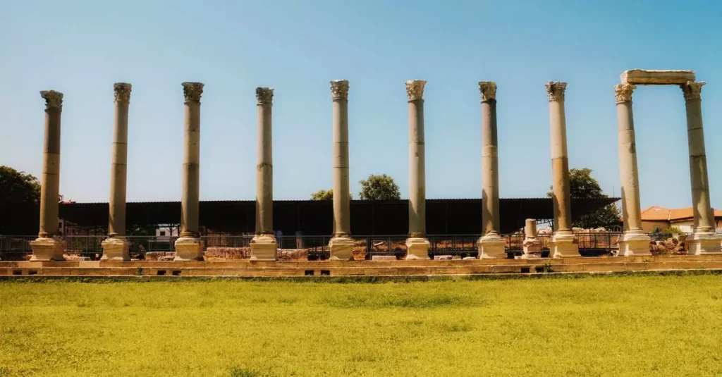 Sunlit view of ancient Roman columns set against clear blue sky.