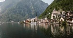 Serene view of Hallstatt village nestled by the lake, with mountains in the background.