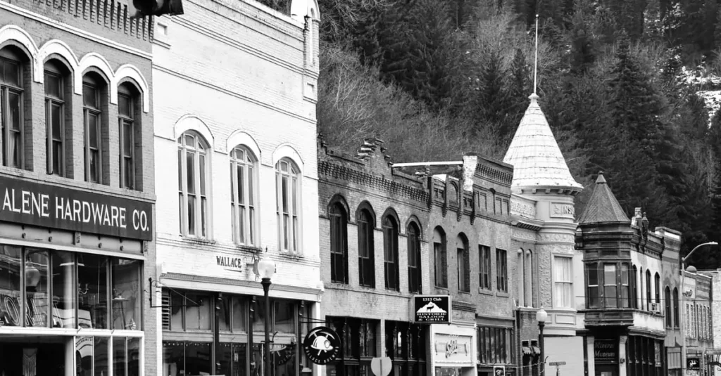 Hidden Small Towns in America: Quiet USA Escapes 7 Black and white photo of historic downtown Wallace, Idaho featuring vintage buildings.