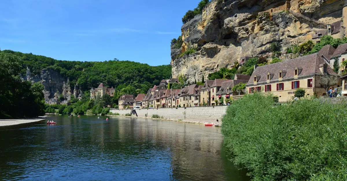 Picturesque village by a river with stone houses and cliffs in France.