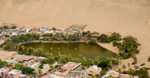 Stunning aerial shot of Huacachina oasis surrounded by desert dunes in Ica, Peru.