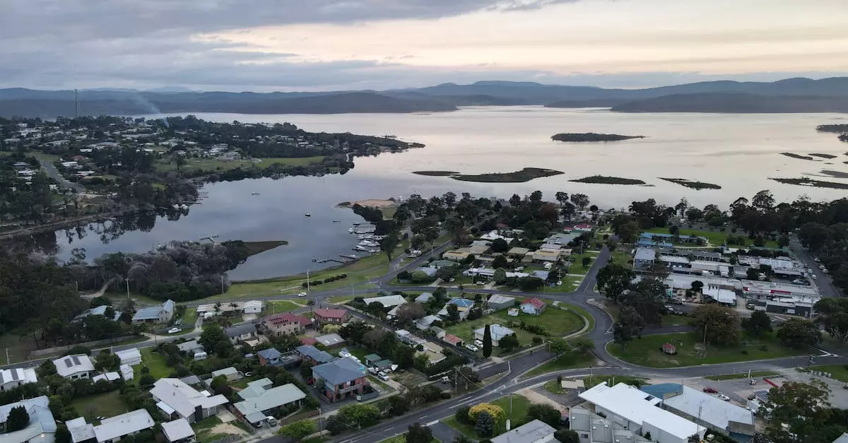 Aerial view of Mallacoota, showcasing the serene lake, residential areas, and lush greenery.