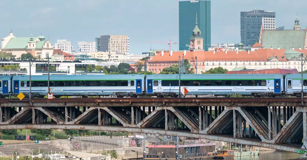 Scenic view of a train crossing a bridge over the Vistula River in Warsaw, showcasing urban architecture.