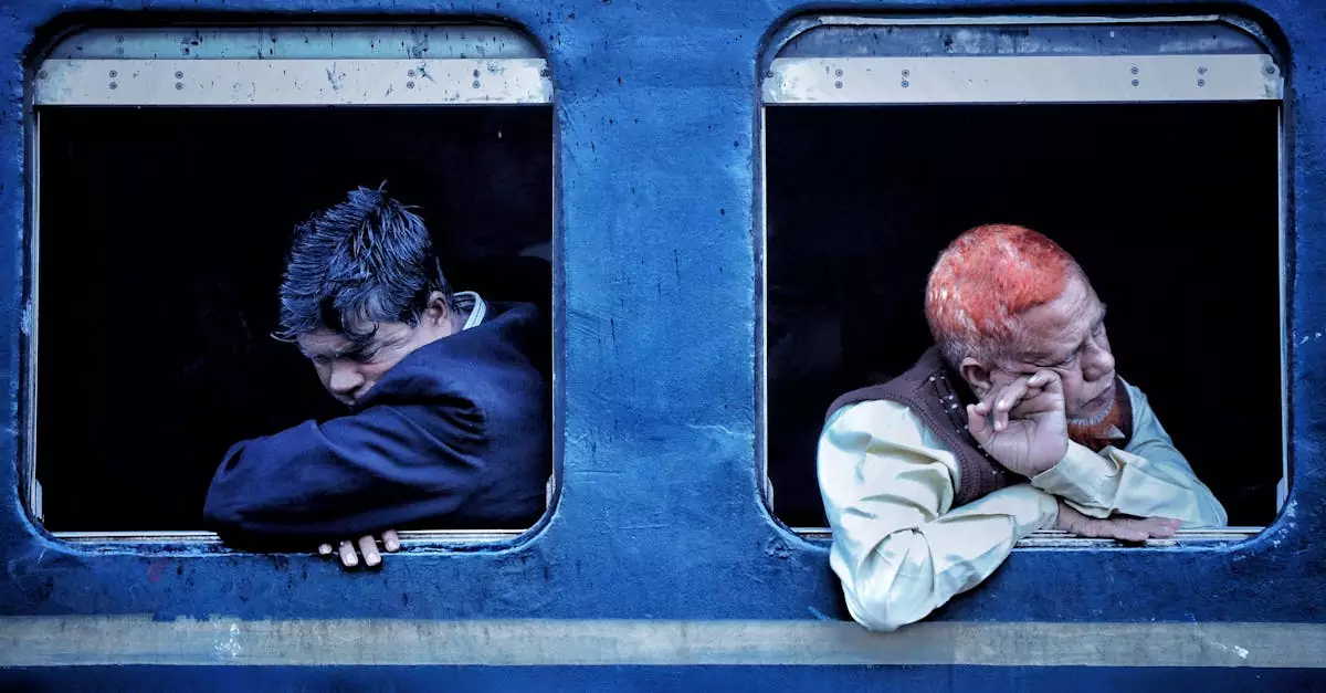 Two men resting on a train, gazing out the windows during their journey.