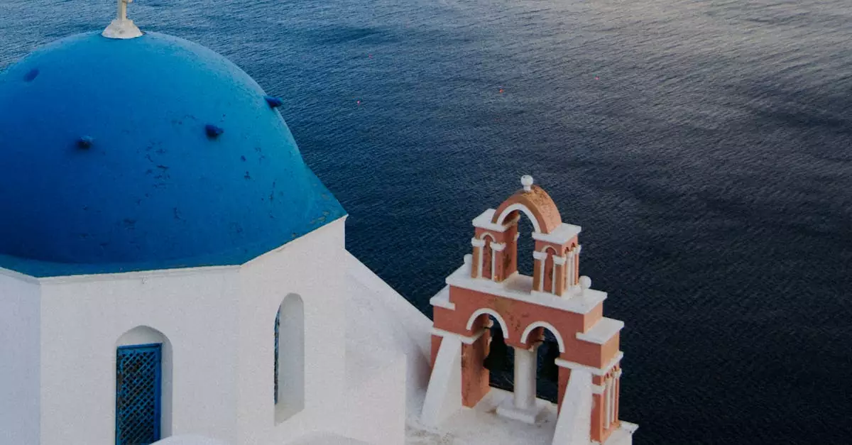 Serene view of the iconic blue dome church in Fira, overlooking the Aegean Sea.
