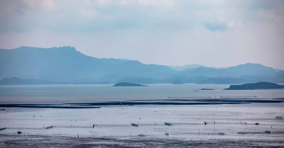 A serene landscape of a coastal area with distant mountains and calm sea waters, captured from Suncheon, South Korea.