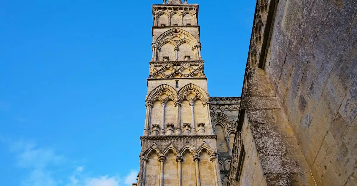 Majestic view of Salisbury Cathedral's Gothic spire reaching into a vibrant blue sky.