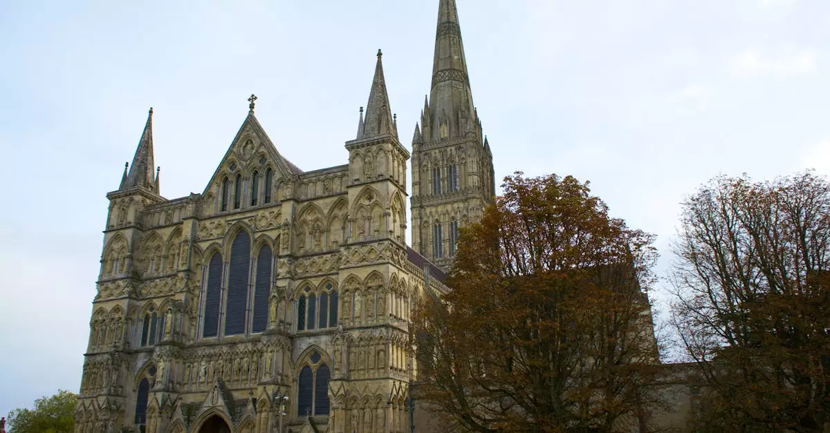 A majestic view of Salisbury Cathedral's gothic architecture surrounded by autumn trees.
