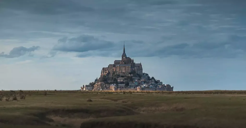 A breathtaking view of Mont-Saint-Michel Abbey in Normandy, France, under a dramatic sky.