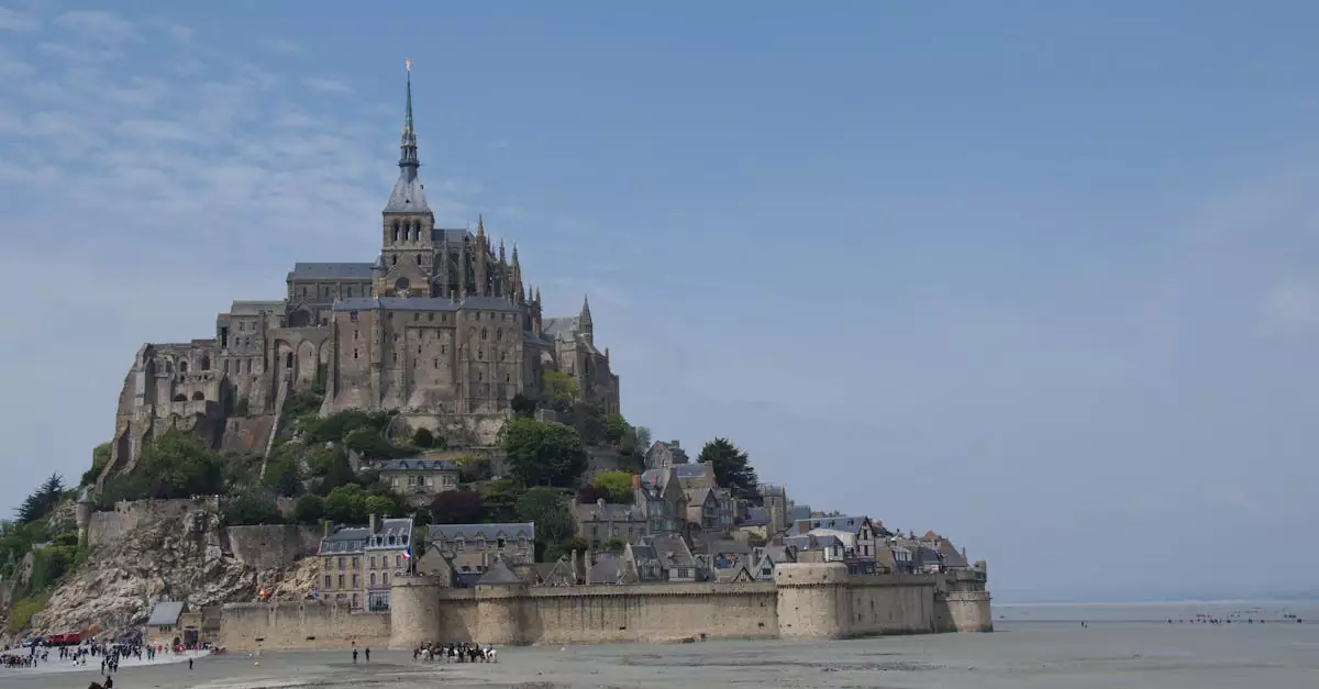 Explore the breathtaking Mont Saint-Michel during low tide with its iconic spire and medieval architecture.