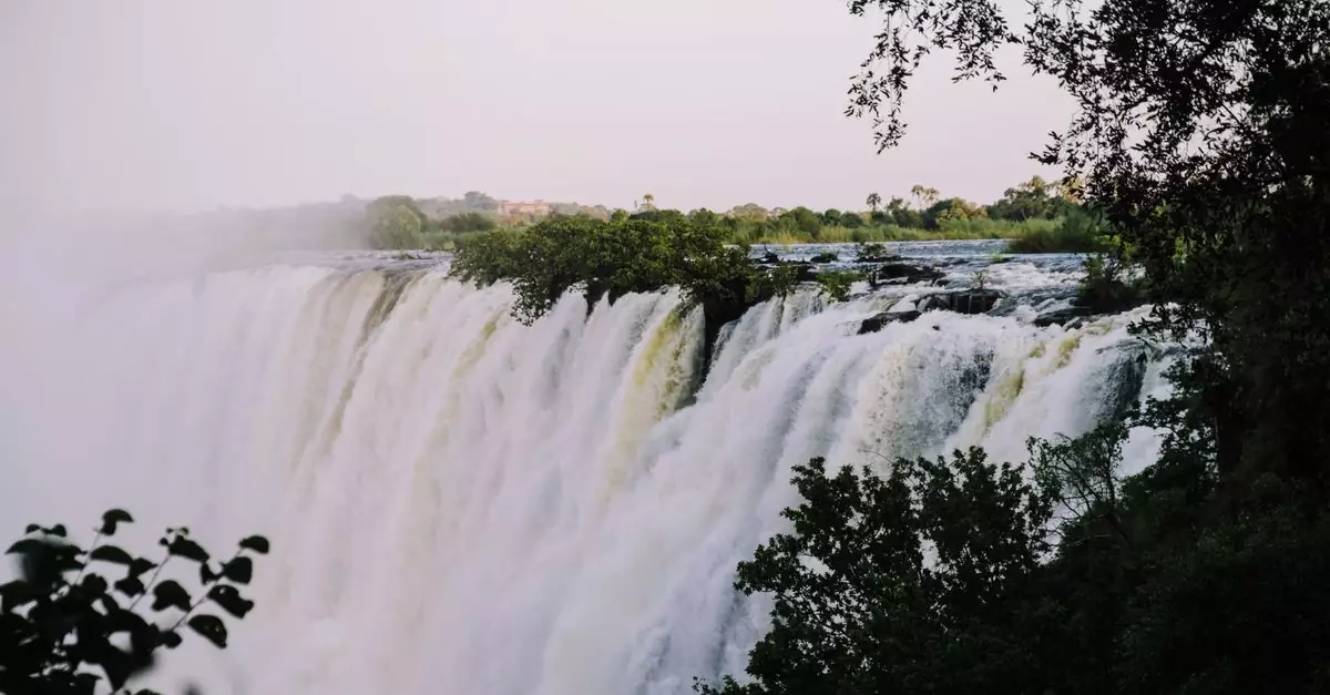 Breathtaking photo of Victoria Falls surrounded by lush greenery under a clear sky.
