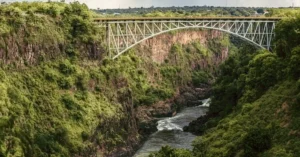 Victoria Falls Bridge gracefully arcs over the lush Batoka Gorge in Zimbabwe, showcasing stunning natural beauty.