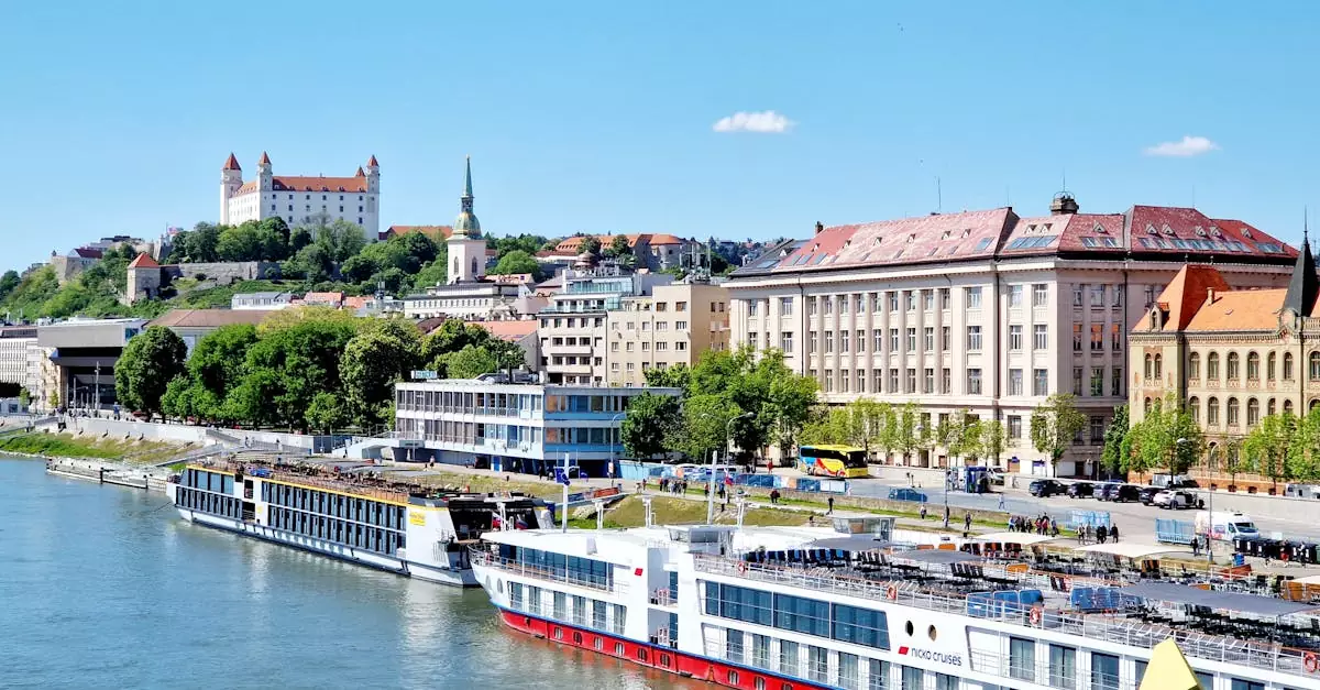 A picturesque aerial view of Bratislava featuring the Danube River and the iconic Bratislava Castle under a clear sky.