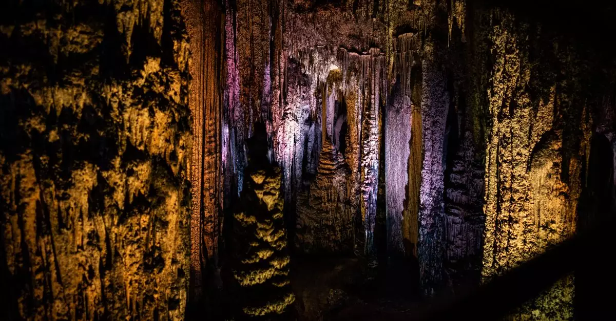 Illuminated stalactites inside a cave in Spain showcasing vivid colors and mysterious beauty.