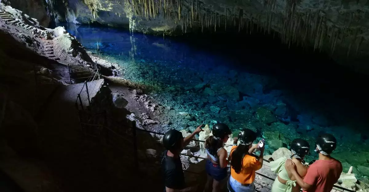 Tourists explore the mesmerizing Gruta do Lago Azul in Bonito, Brazil, showcasing natural beauty and adventure.