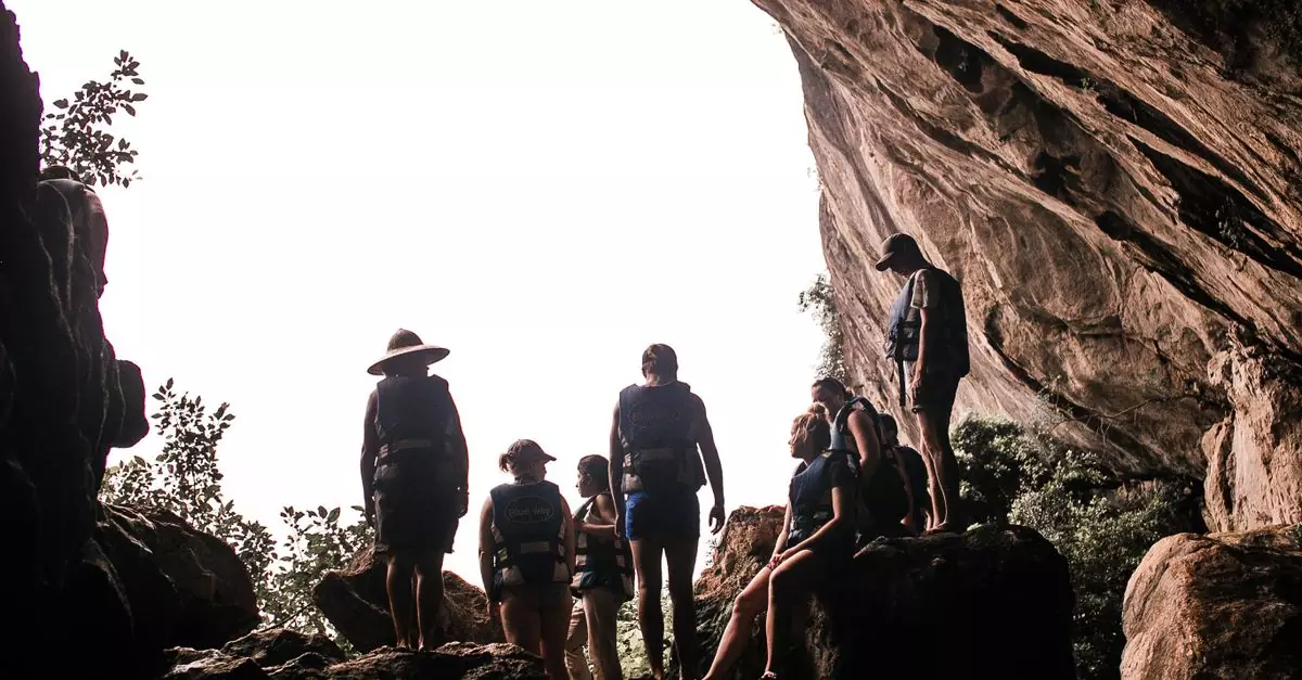 A diverse group standing inside a large natural cave, capturing the essence of adventure.