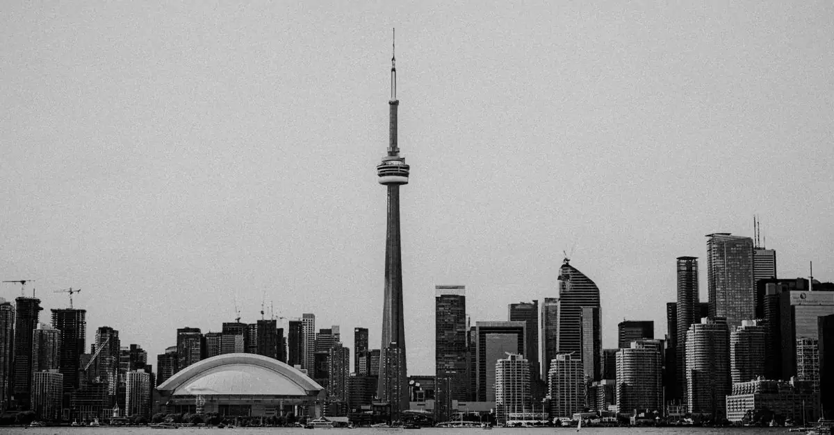 A black and white view of Toronto's skyline featuring the iconic CN Tower and modern architecture.