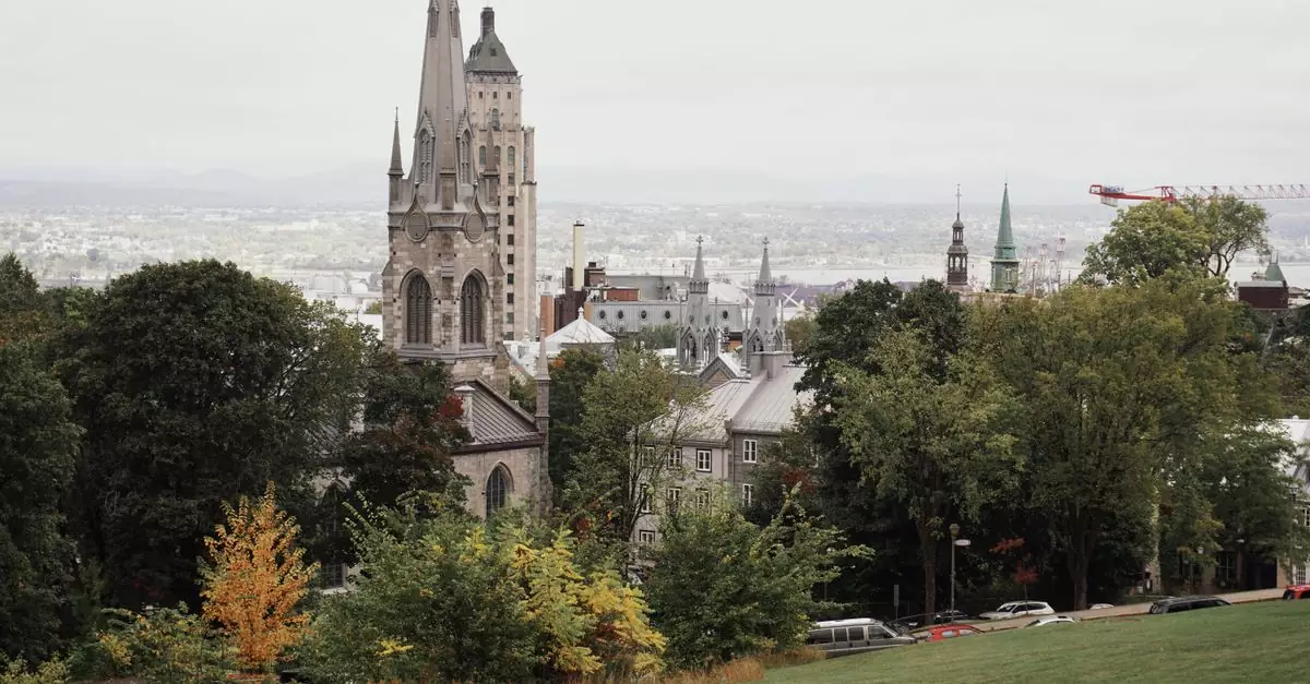 A picturesque view of Quebec City featuring its historic church with autumn foliage.