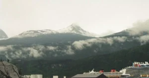 A cruise ship docked in a picturesque harbor with snow-capped mountains in the background, Skagway, Alaska.