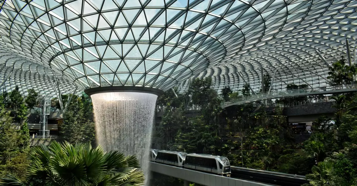 Modern indoor waterfall at Jewel Changi Airport, showcasing lush greenery and cutting-edge architecture.