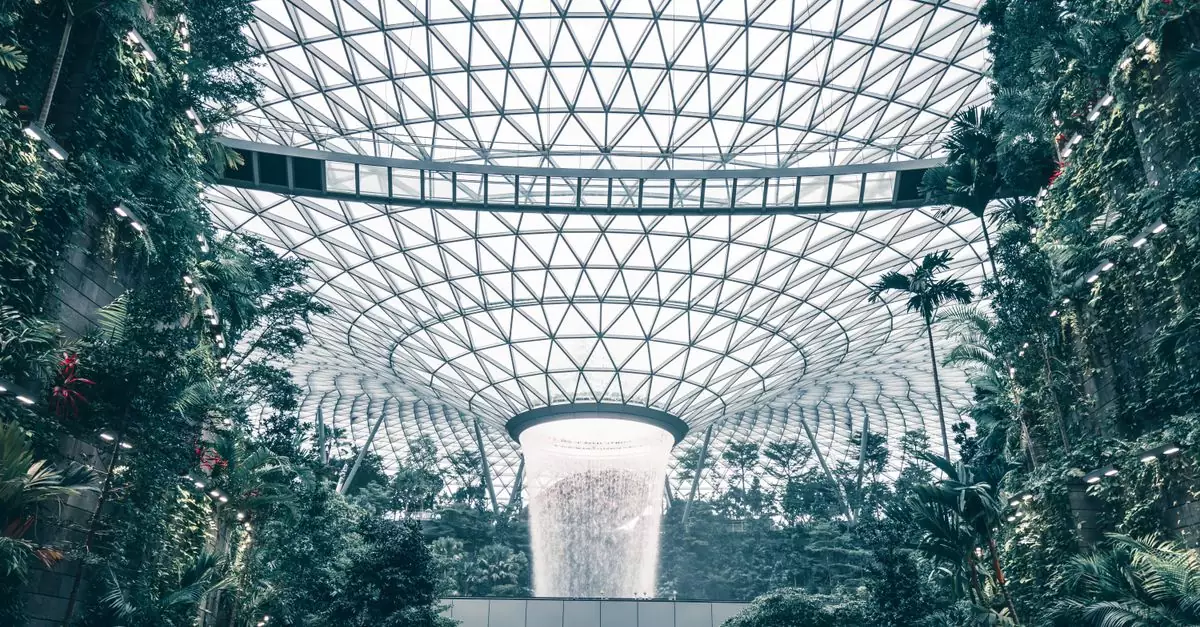 Lush indoor garden with impressive waterfall at Jewel Changi Airport, Singapore.