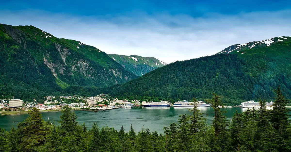 Beautiful coastal city with mountains and cruise ships under a clear blue sky.