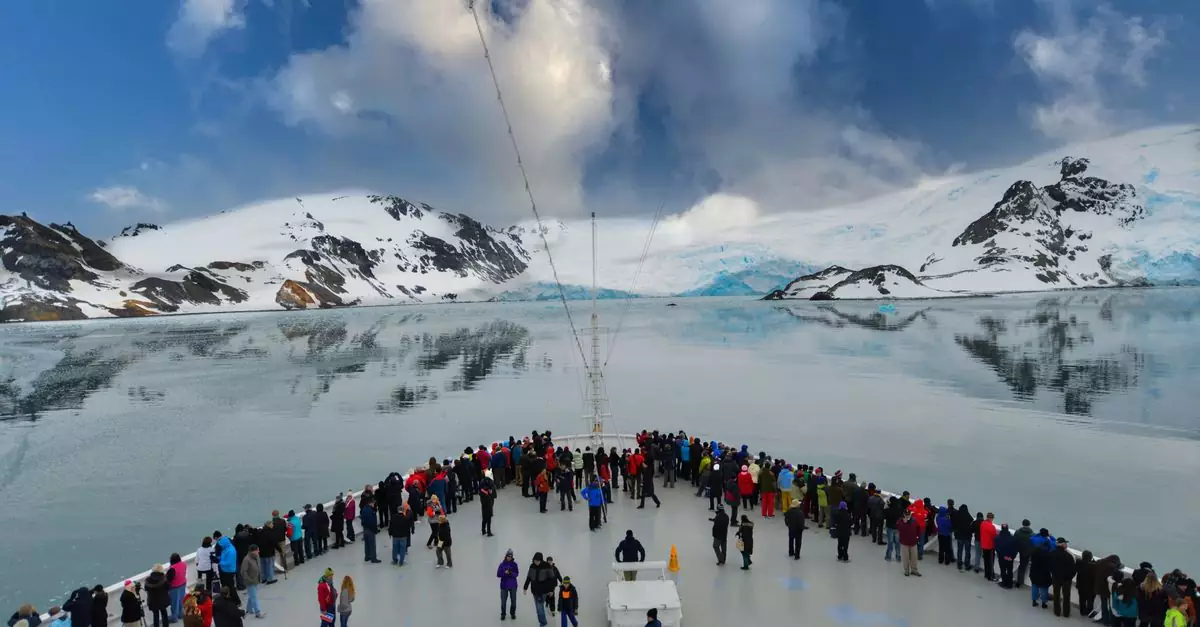 A cruise ship deck filled with people enjoying stunning views of Antarctic icebergs and snow-capped mountains.