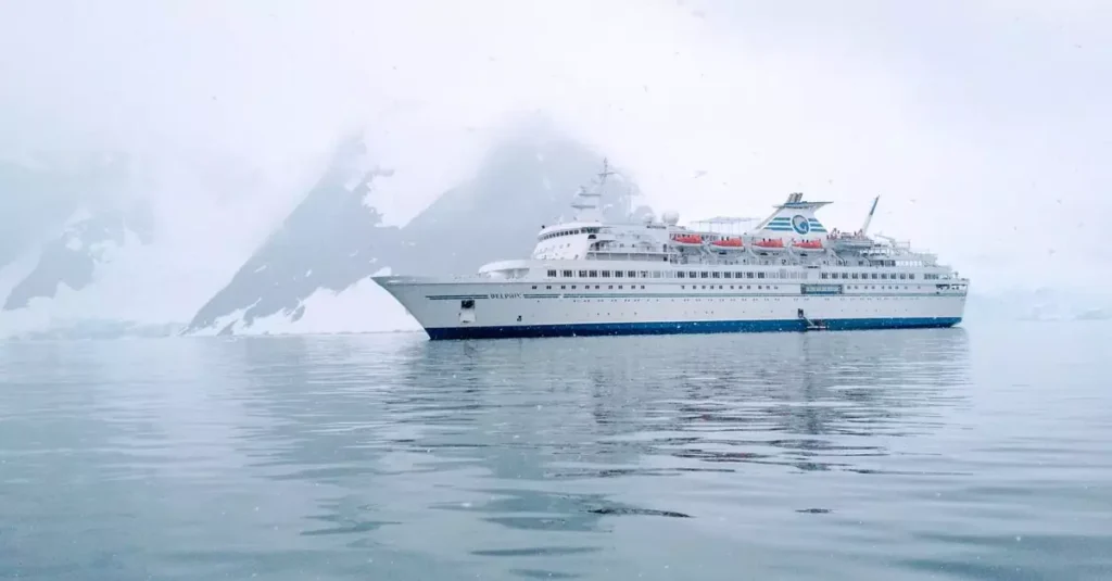Best Antarctica Cruises: Your Ultimate Guide 2 A cruise ship sails calmly through the icy waters of Antarctica, surrounded by snow-capped mountains.