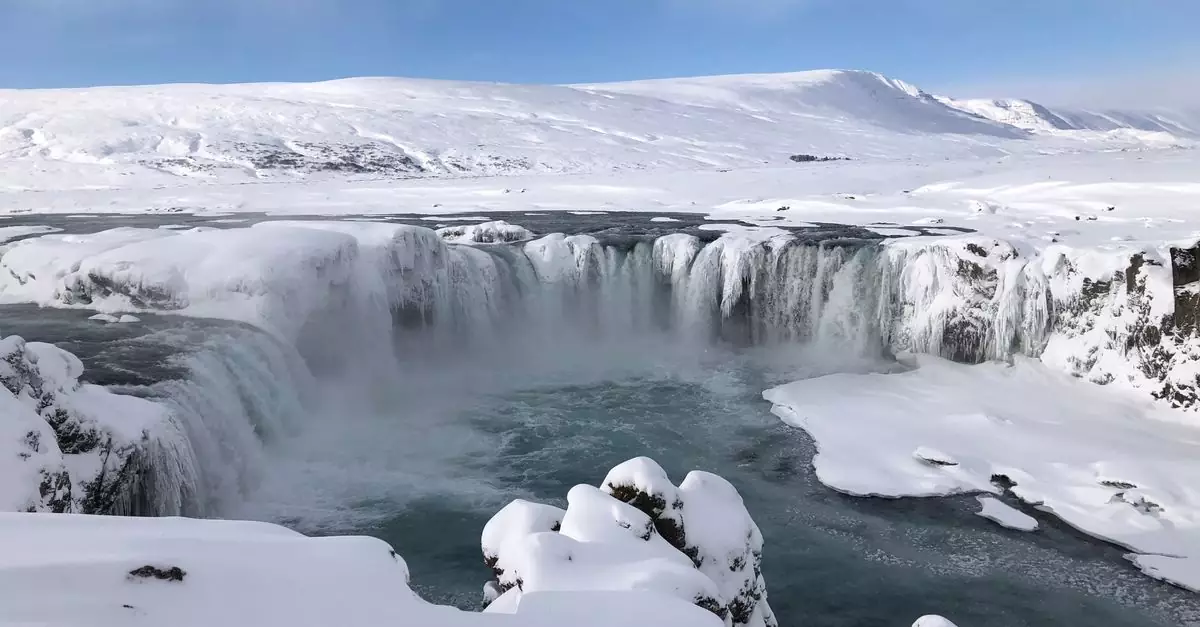 Snow-covered Godafoss waterfall in Iceland offers a breathtaking winter view.