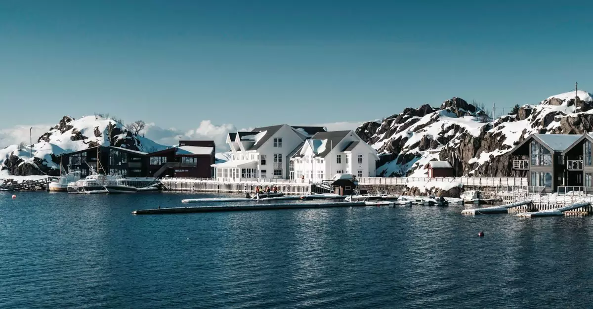 Explore a serene Arctic fjord resort surrounded by snow-covered mountains, showcasing tranquil beauty.