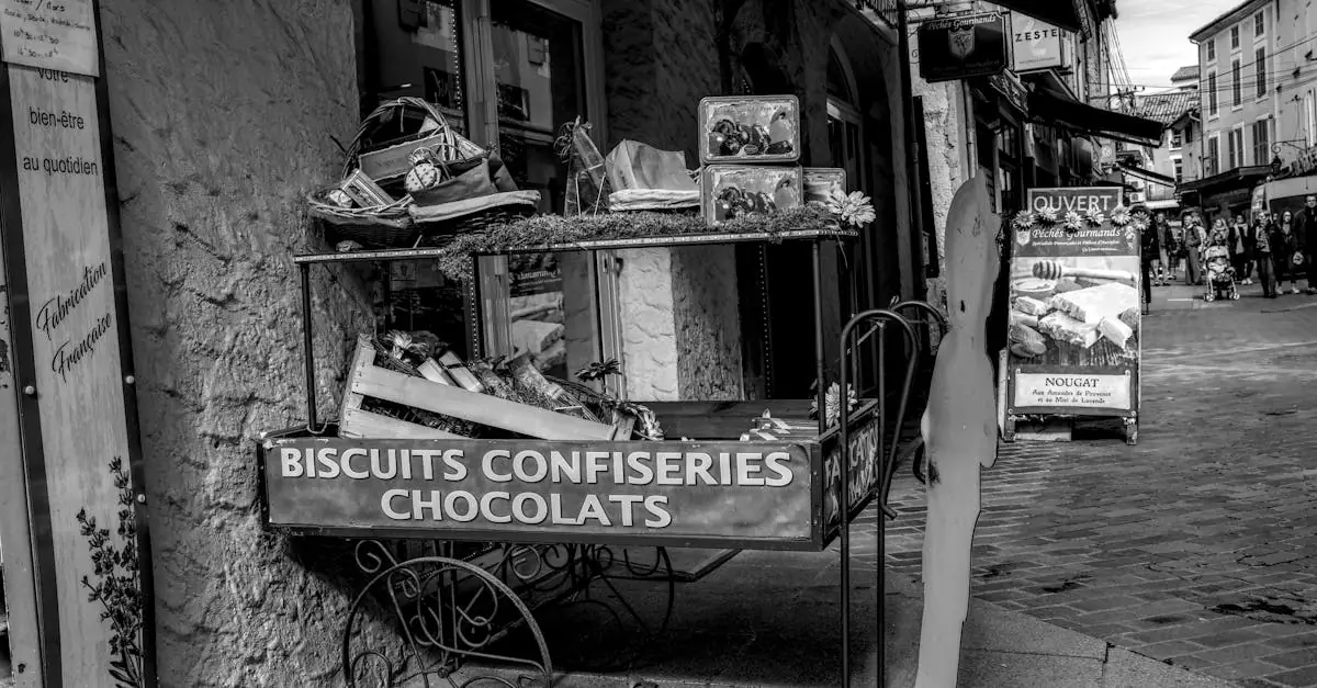 Black and white photo of a French candy and chocolate cart on a cobblestone street.