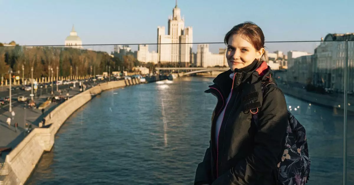 A woman enjoys a sunny day by the Moscow River with iconic cityscape views.