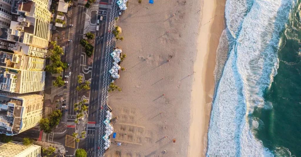 A stunning aerial shot showcasing Rio de Janeiro's scenic beachfront at sunset, with golden sands and cityscape.
