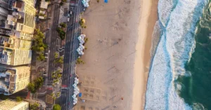 A stunning aerial shot showcasing Rio de Janeiro's scenic beachfront at sunset, with golden sands and cityscape.