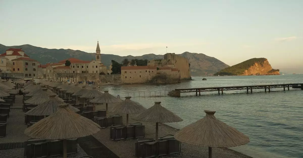 Scenic view of Budva Old Town at sunset with beach umbrellas in Montenegro.