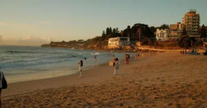 People enjoying a warm evening at Coogee Beach, Sydney during sunset. Relaxing coastal vibe.