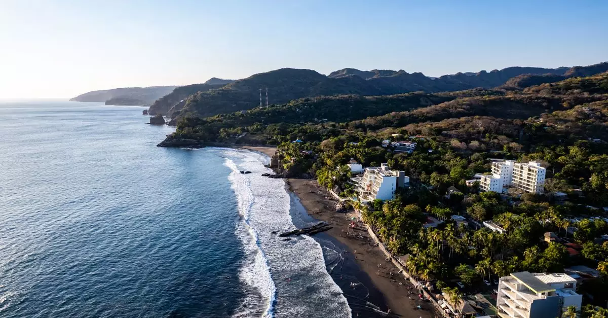 A stunning aerial view of El Zonte Beach, showcasing the coastline and surrounding hills in El Salvador.