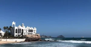 Captivating view of a beachfront building in Mazatlán, Sinaloa with clear skies and ocean waves.