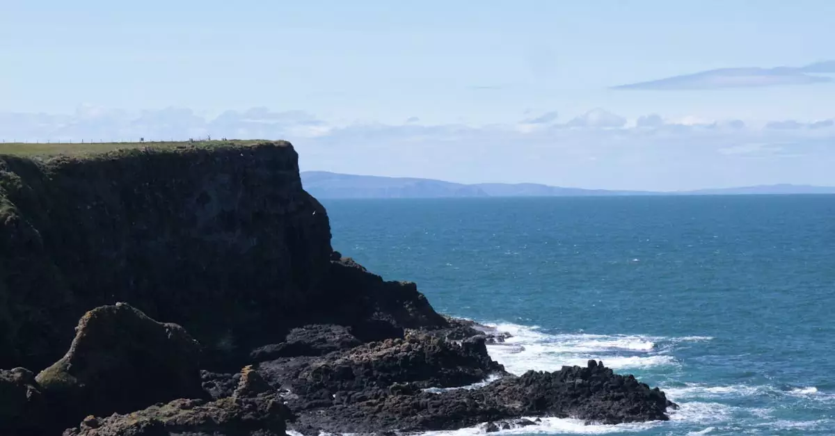 Capture of dramatic cliffs meeting the ocean along Northern Ireland's coast.