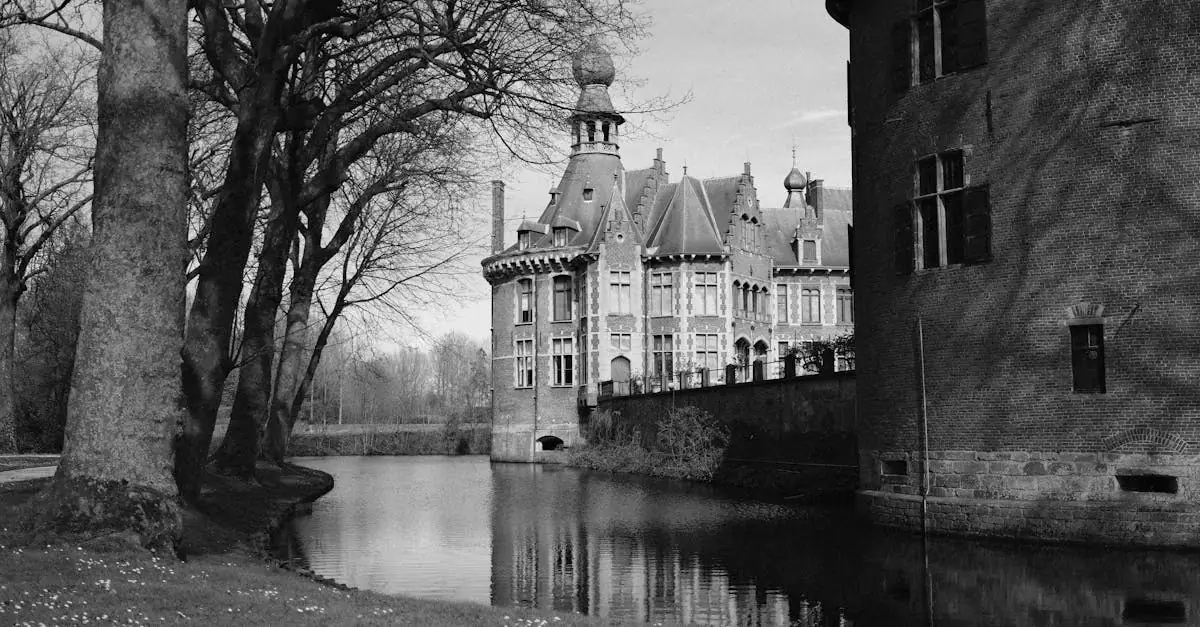 Black and white image of Ooidonk Castle by the riverbank in Ghent, Belgium.