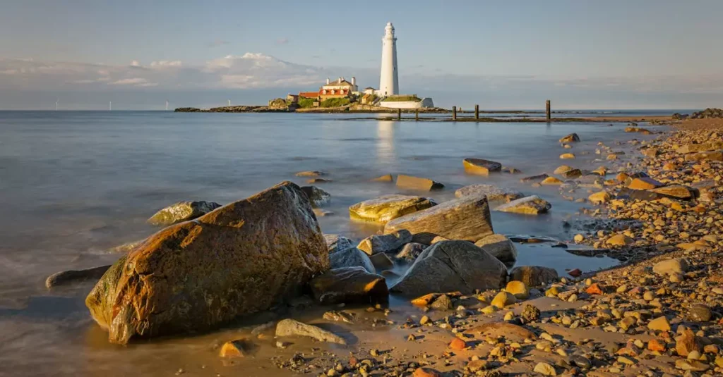 Picturesque scene of St Mary's Lighthouse and rocky coastline in England.