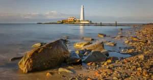 Picturesque scene of St Mary's Lighthouse and rocky coastline in England.